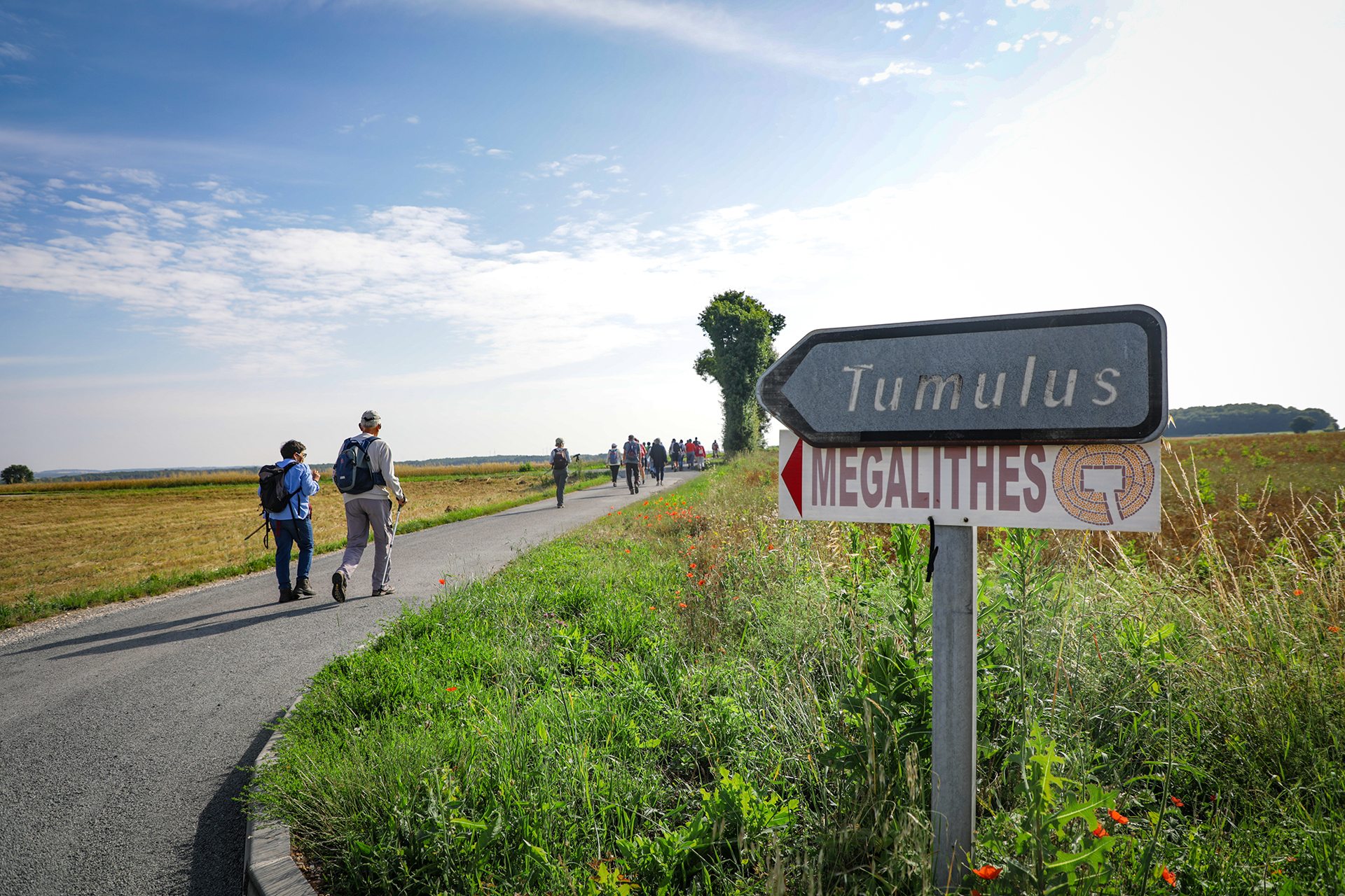 Randonneurs marchant vers les tumulus géants de Tusson