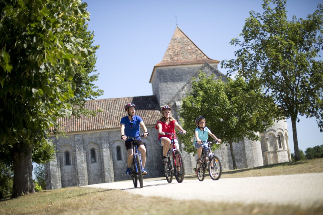 Famille à vélo devant l'église de Lichères